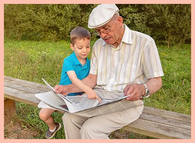 Senior,man,reading,newspaper,and,cute,child,pointing,an,article