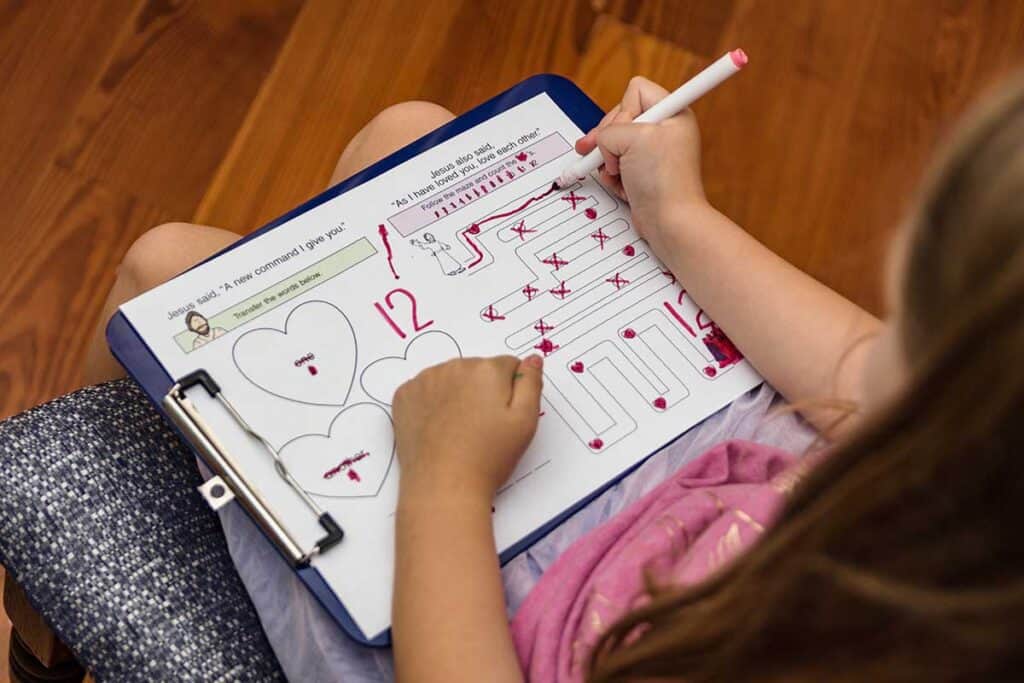 Child using a notebook to draw and take notes during a church service to stay engaged